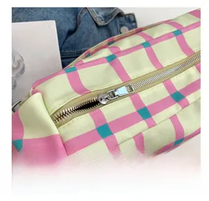 Detailed close-up of the smooth silver metal zipper on a colorful plaid canvas bag
