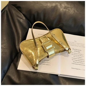 Detail of luxury gold underarm bag with crocodile pattern and decorative square buckle