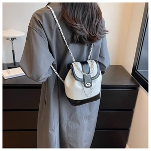 Detail of mini black and white backpack with chain strap and silver metal buckle closure
