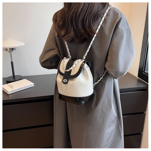 Detail of black and white mini backpack with silver chain straps and metallic twist lock