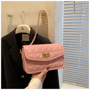 Gros plan sur le sac bandoulière matelassé rose avec chaîne dorée et fermoir rotatif
