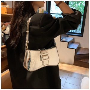 Close-up of silver crocodile embossed faux leather with square buckle on underarm bag