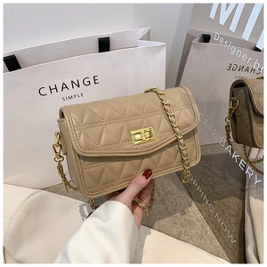 Détail du sac beige matelassé à losanges avec fermoir rotatif doré et chaîne