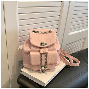Detalle de una mini mochila rosa claro con cadena de metal plateado y cierre