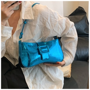 Detail of metallic blue crocodile pattern shoulder bag with square buckle closure