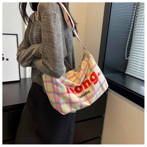 Detail of colorful plaid canvas crossbody bag featuring bold Jeong brand lettering