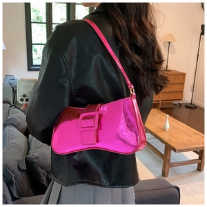 Crocodile pattern pink underarm bag with metal buckle shown in a lifestyle setting