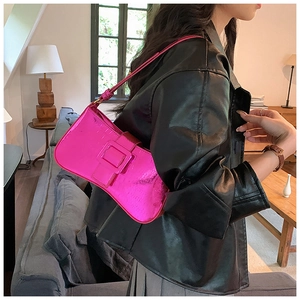 Detail of fuchsia crocodile embossed baguette bag with metallic finish and square buckle