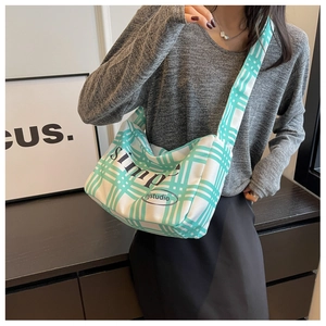Detail of white and mint green checkered canvas messenger bag with wide shoulder strap