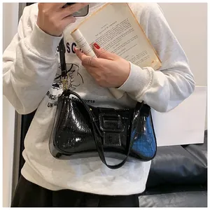 Detail of black faux crocodile leather underarm bag with decorative square buckle buckle