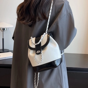 Classic black and white bucket backpack with chain strap and metal lock closure