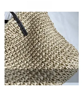 Detail shot of beige straw woven bag with intricate texture and premium leather handle
