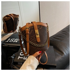 Close-up of vintage bucket bag featuring brown monogram leather and gold chain detail