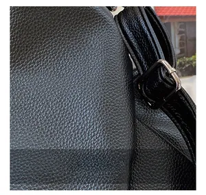 Close-up of black lychee grain PU leather texture and silver buckle on large tote bag