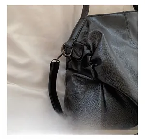 Close-up of black lychee-grain leather bag featuring a durable dark metal swivel hook