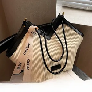 Vue détaillée du sac cabas en nylon plissé crème avec bordure noire et bandoulière