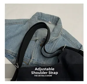 Detailed shot of the black canvas bag featuring a practical adjustable shoulder strap