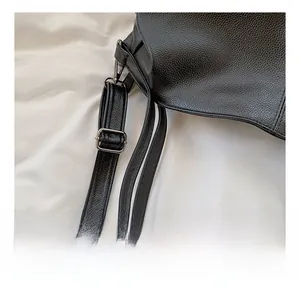 Detail of adjustable shoulder strap on black lychee texture PU leather tote bag