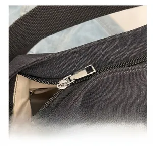 Close-up of smooth silver metal zipper on a black canvas multi-way backpack