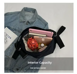 Internal capacity of the black canvas tote showing tablet, phone, and daily essentials