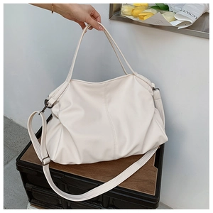 Close-up of cream white tote bag with lychee grain leather and adjustable strap details