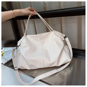 Detail of creamy white faux leather tote showing the wide bottom and soft pleated texture