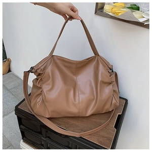 Detail of tan pebble leather tote bag showing soft texture and adjustable strap