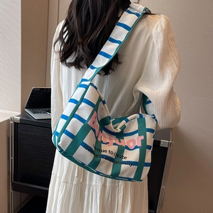 Canvas plaid shoulder bag with colorful Bonjuor print shown in a stylish side view