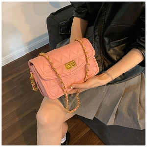 Détail du sac à bandoulière rose matelassé avec chaîne dorée et fermoir tournant en métal