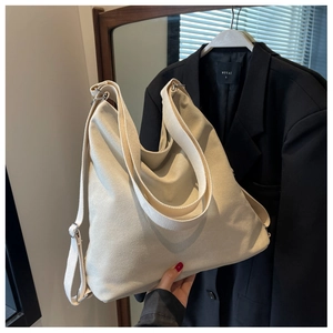 Detailed view of the thick beige canvas tote bag with adjustable wide shoulder straps