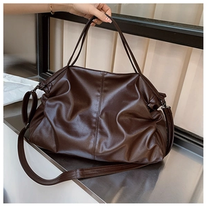 Detailed close-up of dark brown tote bag with premium lychee grain texture and soft folds