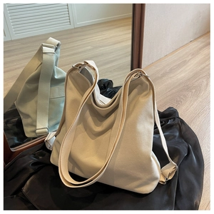 Detail of wide adjustable canvas strap and metal ring on large off-white tote bag