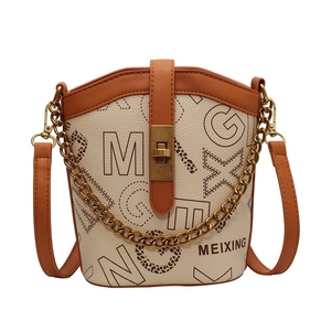 Elegant beige bucket bag with brown trim, letter print, and gold chain detail