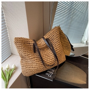 Dettaglio ravvicinato della texture della borsa tote in paglia con manici in pelle