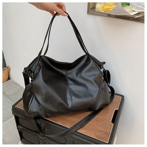 Detail of black pebbled leather tote bag with thick adjustable shoulder strap