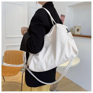 Detailed view of the soft lychee grain texture and adjustable strap on a white tote bag