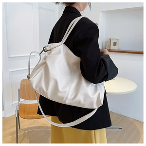 Close-up of off-white lychee grain leather tote bag with adjustable shoulder strap