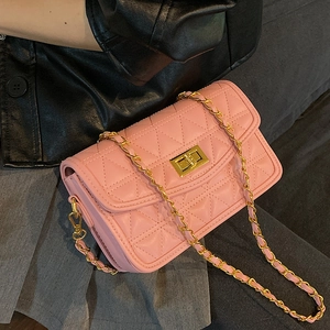 Sac bandoulière matelassé rose avec chaîne dorée et fermoir sur un fond sombre moderne