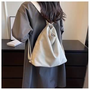 Detail showing high-quality off-white canvas texture and silver metal ring on the bag