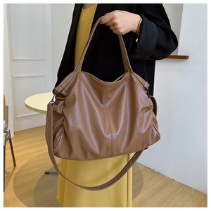 Close-up of caramel tote bag showing lychee grain leather texture and dark hardware
