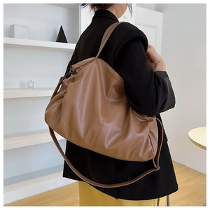 Detail of soft brown pebble leather texture on large capacity commuter shoulder bag