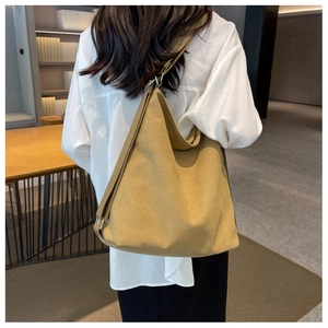 Detail of adjustable silver buckle on a large canvas hobo bag in mustard yellow color