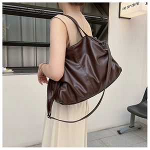 Detailed macro view of deep brown large tote bag with high-quality litchi grain texture