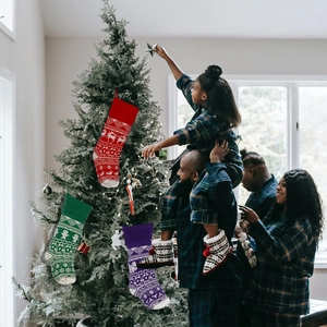 Detail of colorful knitted Christmas stockings with reindeer patterns in a cozy home setting
