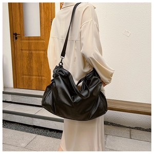 Detail of black large capacity tote bag featuring pleated cloud texture and PU leather finish