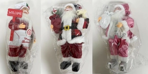 Three assorted standing Santa Claus dolls in festive costumes with gift bags and welcome signs