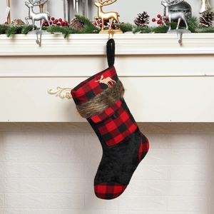 Detail of red and black buffalo plaid Christmas stocking with golden reindeer and fur trim