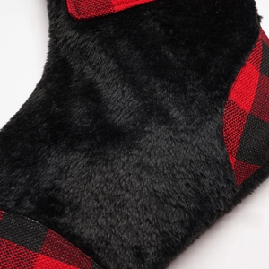 Detail of red and black buffalo check fabric with plush black faux fur on a Christmas stocking