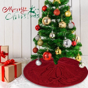 Macro detail of red cable knit Christmas tree skirt with ribbon ties on white rug