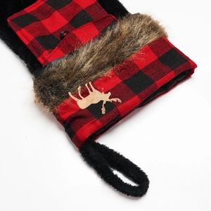 Detail of red and black buffalo plaid Christmas stocking with brown faux fur and wooden elk